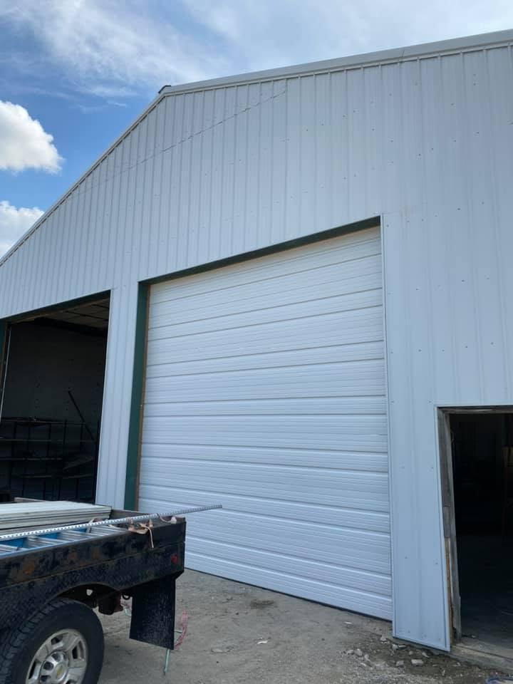 Clean white commercial overhead door installation on a metal building