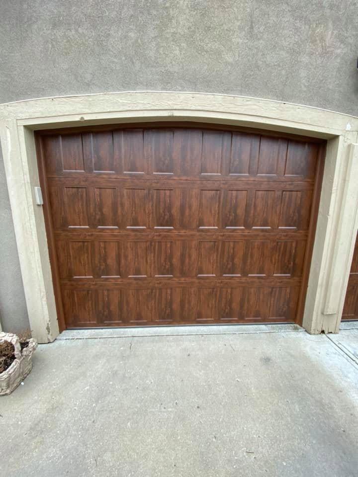 Close-up of a wood-grain carriage house garage door installed by Carlisle Overhead Doors